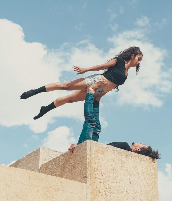 Man performing a controlled strength exercise in a minimalist dark setting.